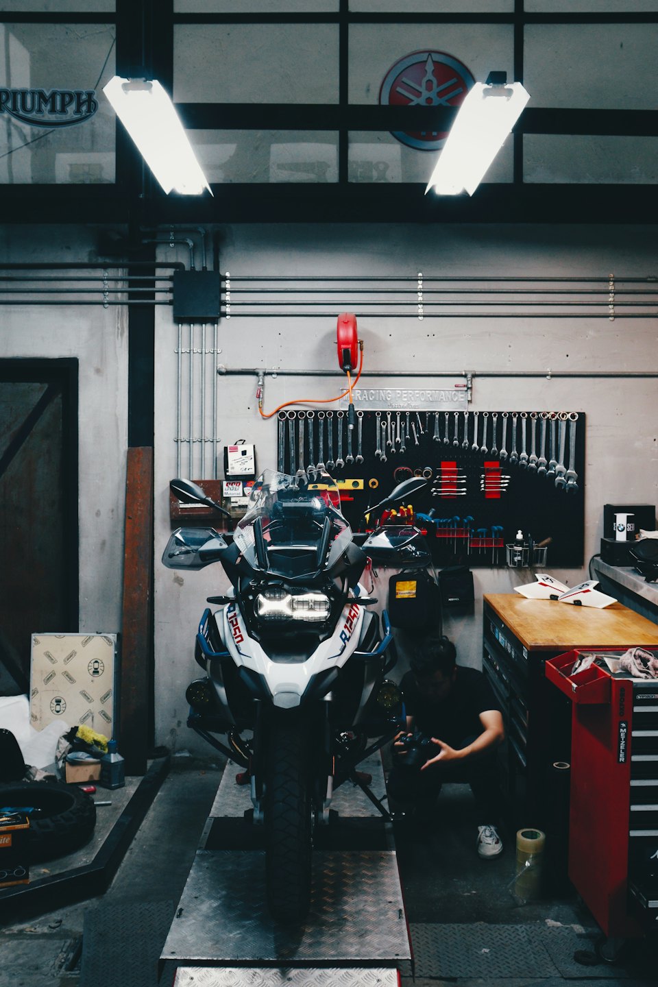 Mann arbeitet an einer BMW R1250 in einer Werkstatt.